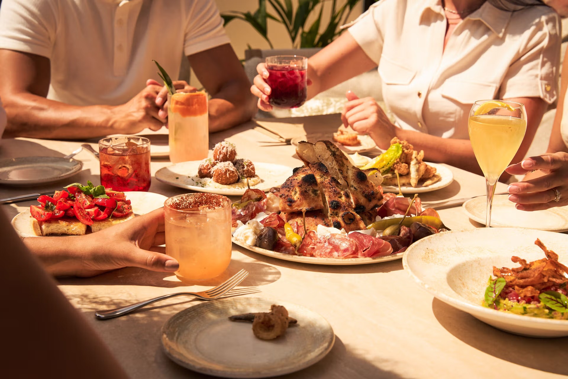 Mesa compartida con platos y coctelería